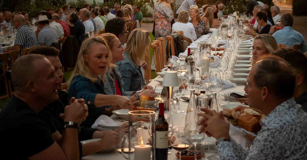 People enjoying themselves at a dinner table for the sunset soiree hermanus